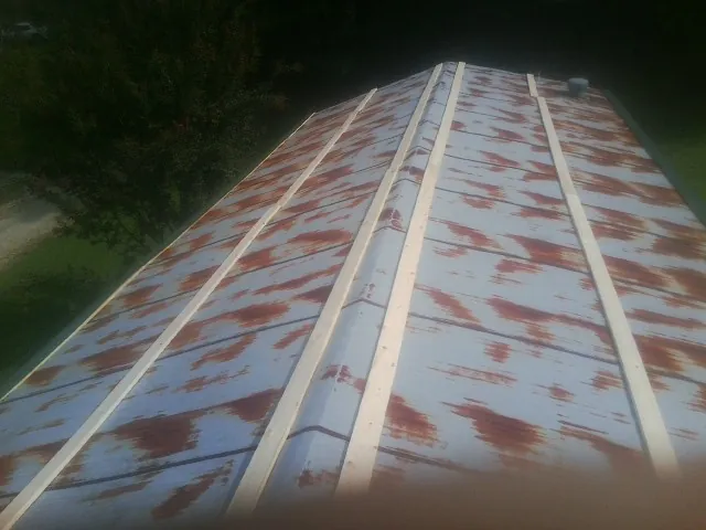 Rusted metal roof panels with new wood purlins before replacement — Storm Damage Roof Repair in Blain by Roofing Brothers