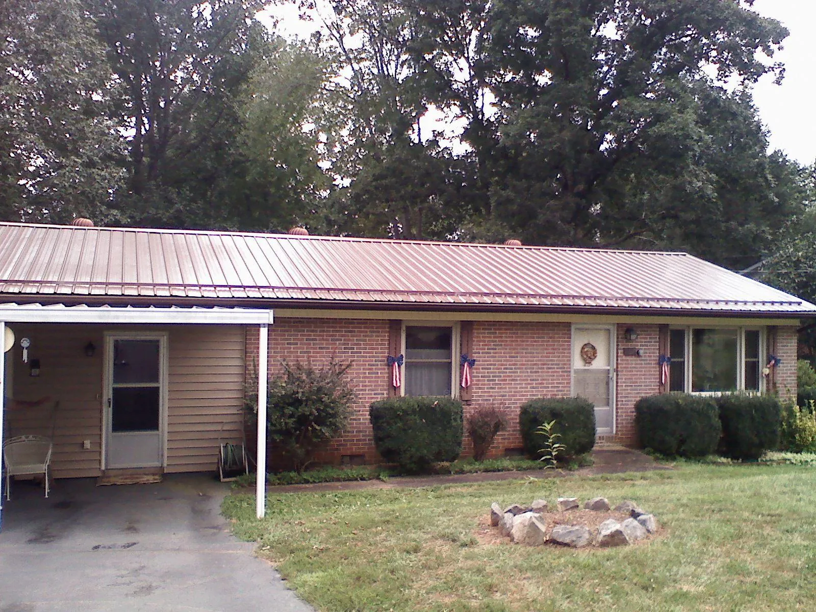 Bronze metal roof and carport on a brick ranch home — Roof Repair work by our crew in Blain